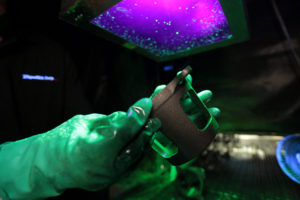 Gloved Hands holding casting durring magnetic particle Non destructive testing